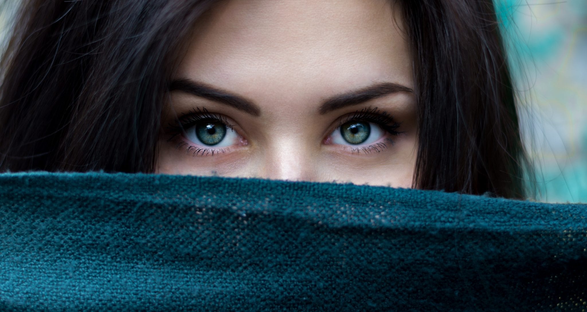 Lady peering over a blue fabric