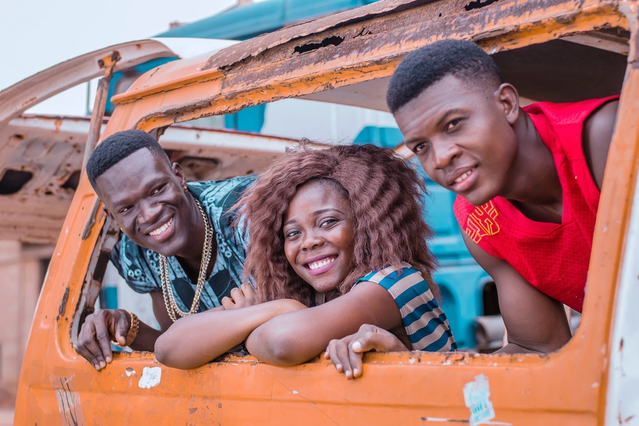 Three students looking out a car broken window