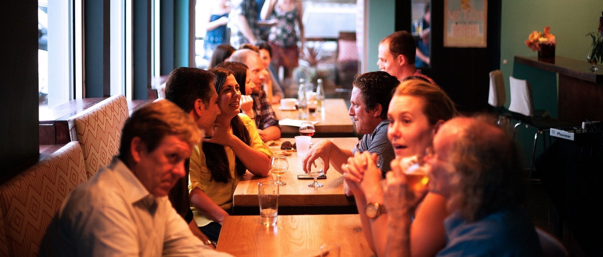Group of students and older men having a drink at a pub