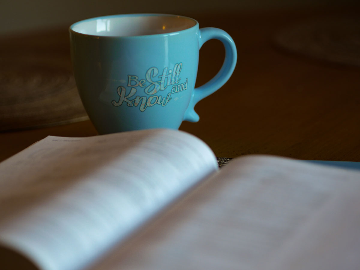 Bible and mug that says be still and know